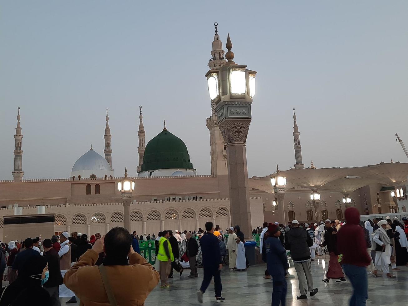 Medina, Saudi Arabia, Dec 2022 - Beautiful evening view in Masjid al-Nabawi, Visitors are seen in the lights of the mosque in the premises of the mosque. photo