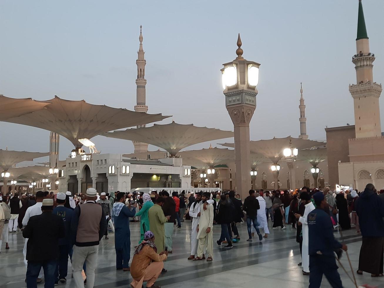 Medina, Saudi Arabia, Dec 2022 - Beautiful evening view in Masjid al-Nabawi, Visitors are seen in the lights of the mosque in the premises of the mosque. photo