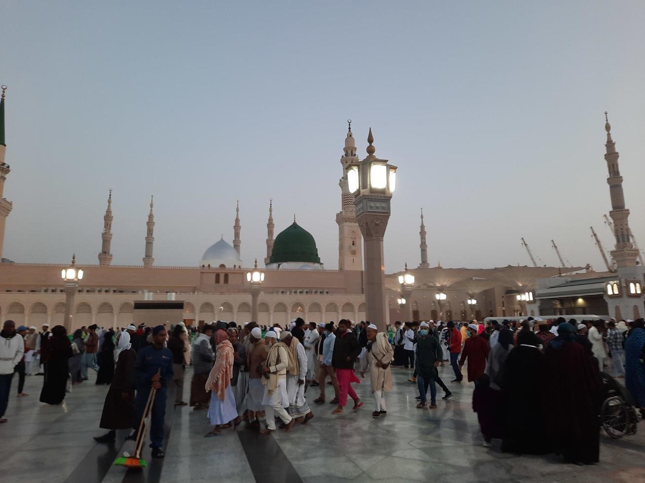 Medina, Saudi Arabia, Dec 2022 - Beautiful evening view in Masjid al-Nabawi, Visitors are seen in the lights of the mosque in the premises of the mosque. photo