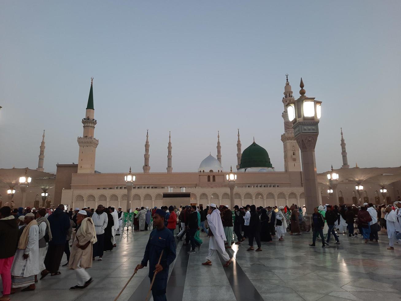 Medina, Saudi Arabia, Dec 2022 - Beautiful evening view in Masjid al-Nabawi, Visitors are seen in the lights of the mosque in the premises of the mosque. photo