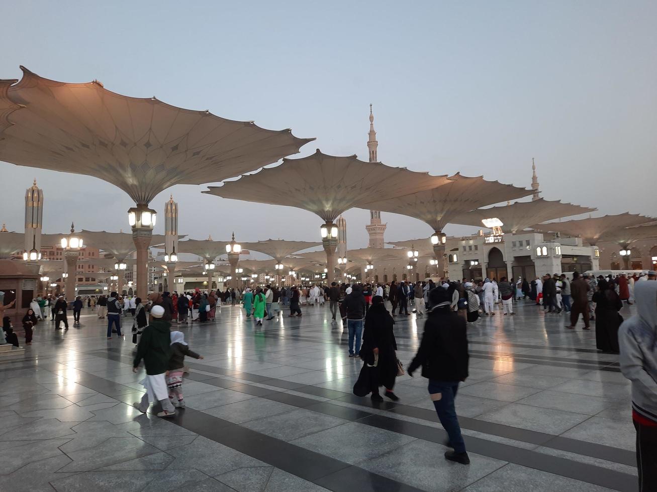 Medina, Saudi Arabia, Dec 2022 - Beautiful evening view in Masjid al-Nabawi, Visitors are seen in the lights of the mosque in the premises of the mosque. photo