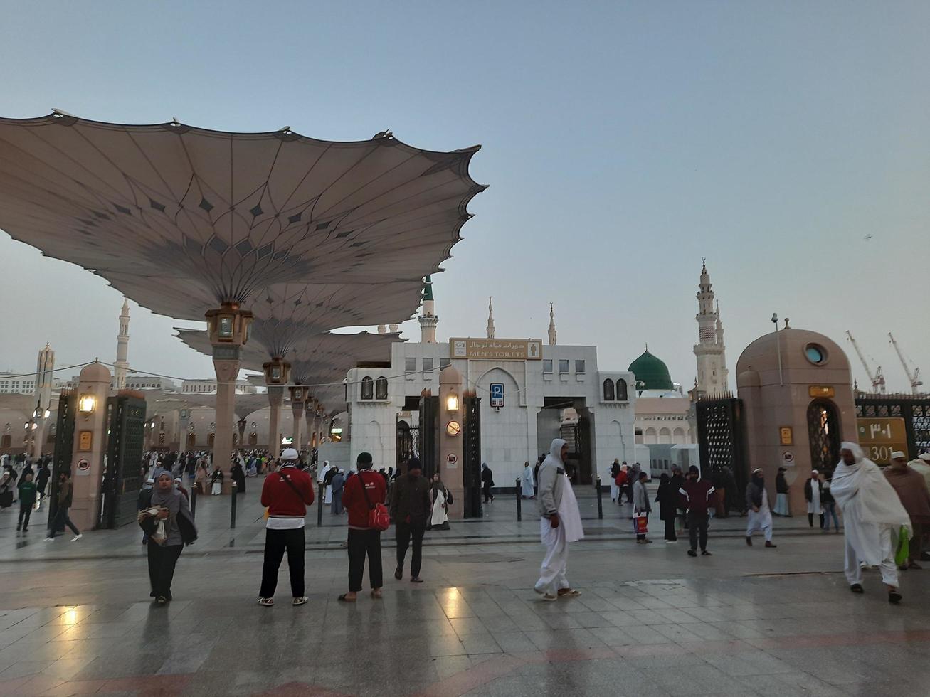 Medina, Saudi Arabia, Dec 2022 - Beautiful evening view in Masjid al-Nabawi, Visitors are seen in the lights of the mosque in the premises of the mosque. photo