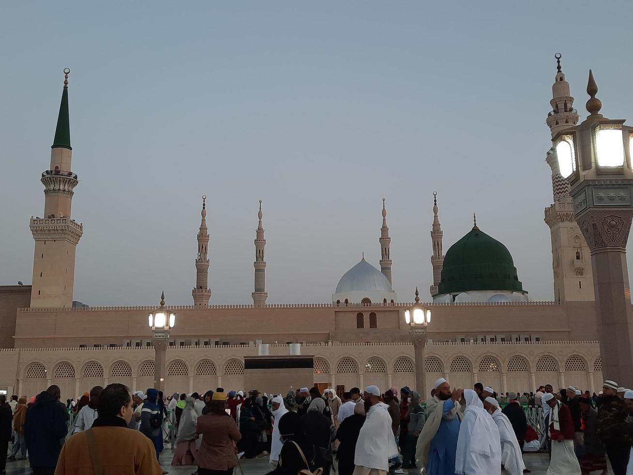 Medina, Saudi Arabia, Dec 2022 - Beautiful evening view in Masjid al-Nabawi, Visitors are seen in the lights of the mosque in the premises of the mosque. photo