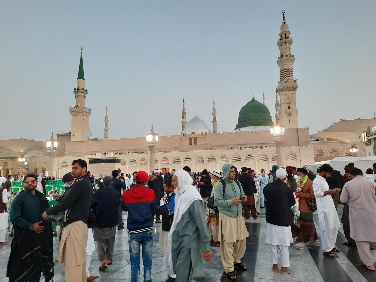 Medina, Saudi Arabia, Dec 2022 - Beautiful evening view in Masjid al-Nabawi, Visitors are seen in the lights of the mosque in the premises of the mosque. photo