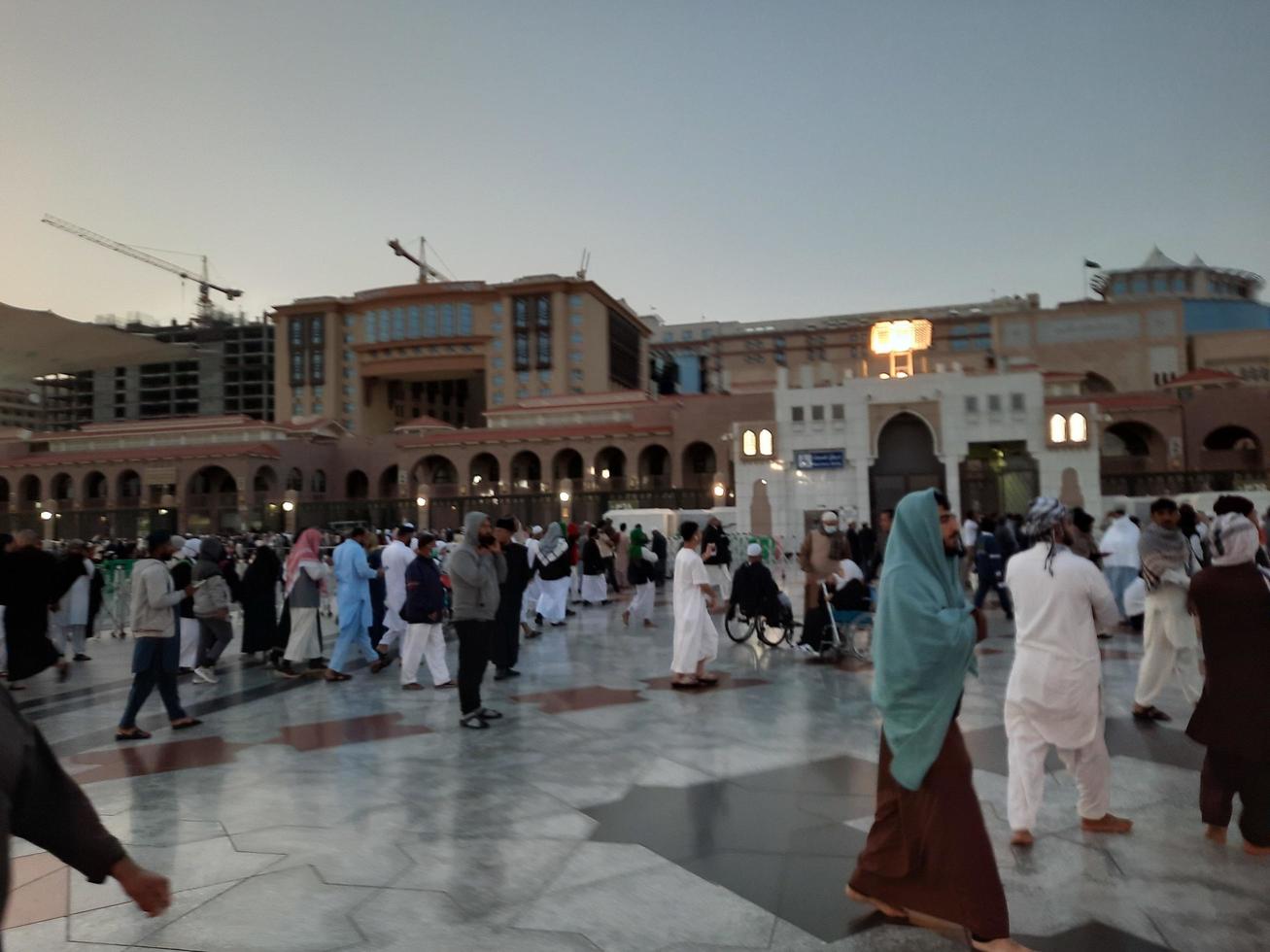 medina, arabia saudita, diciembre de 2022 - hermosa vista nocturna en masjid al-nabawi, los visitantes son vistos en las luces de la mezquita en las instalaciones de la mezquita. foto