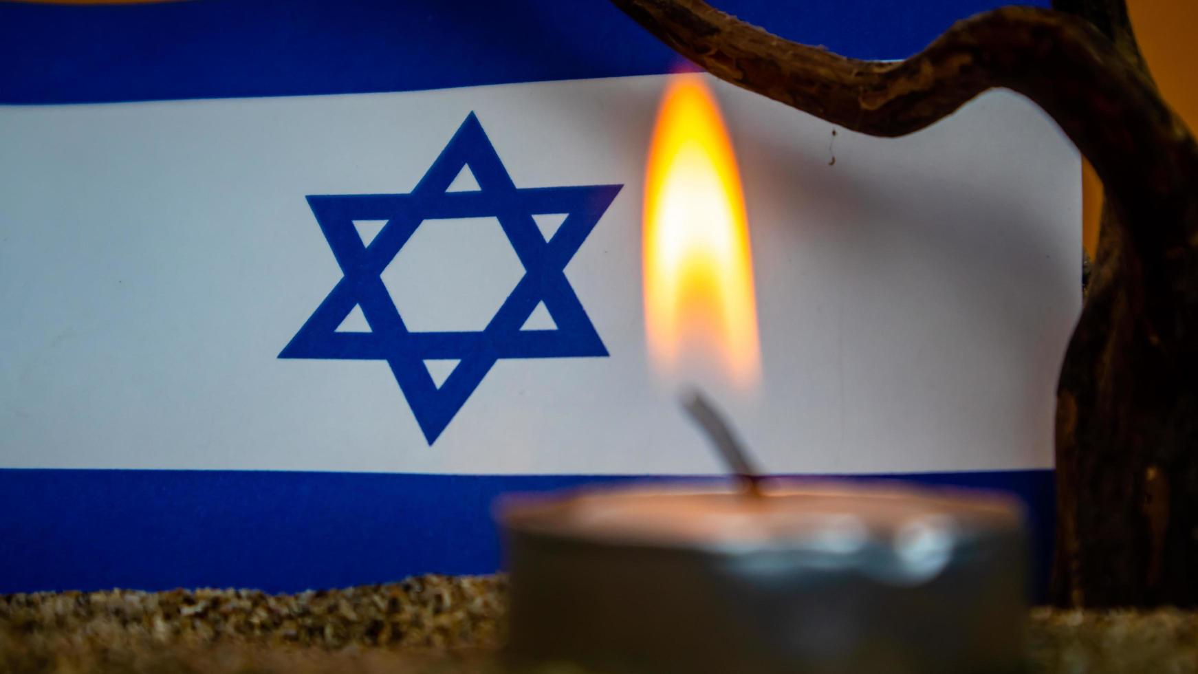 Israeli flag and candles burning in front of it, Holocaust memory day photo