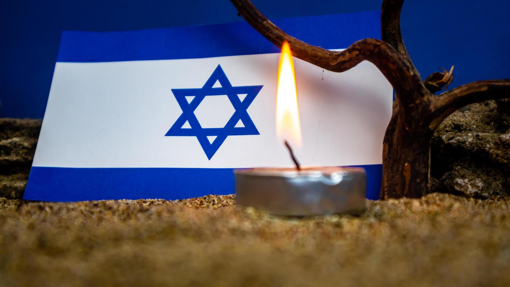 Israeli flag and candles burning in front of it, Holocaust memory day photo