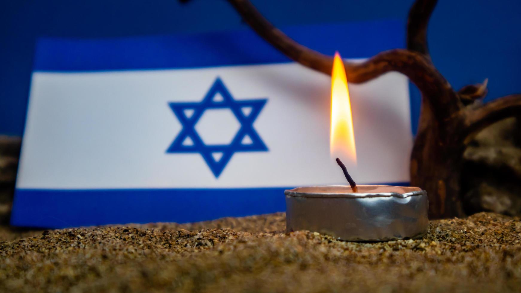 Israeli flag and candles burning in front of it, Holocaust memory day photo