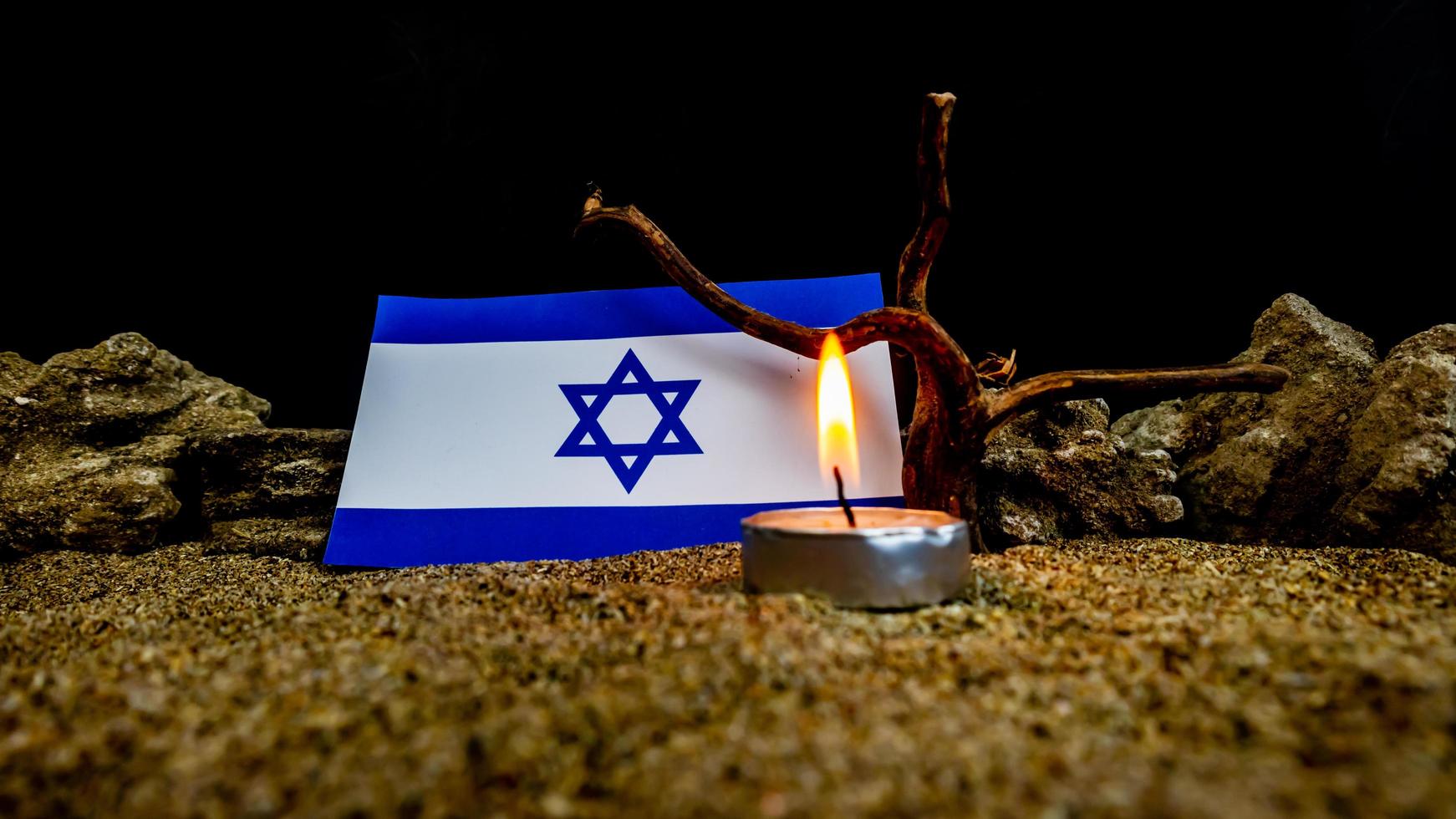 Israeli flag and candles burning in front of it, Holocaust memory day photo