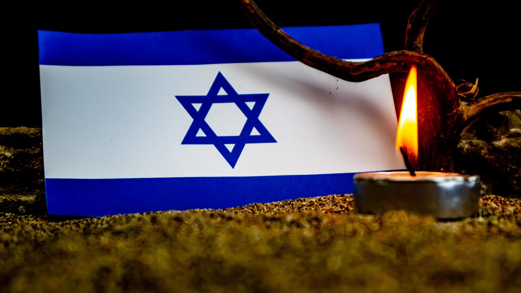 Israeli flag and candles burning in front of it, Holocaust memory day photo