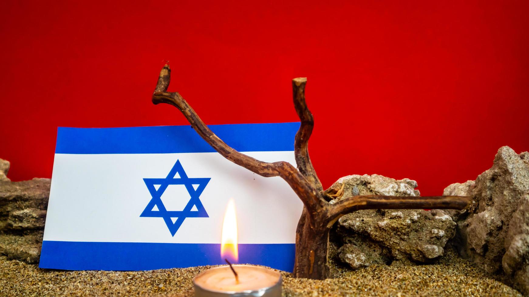 Israeli flag and candles burning in front of it, Holocaust memory day photo