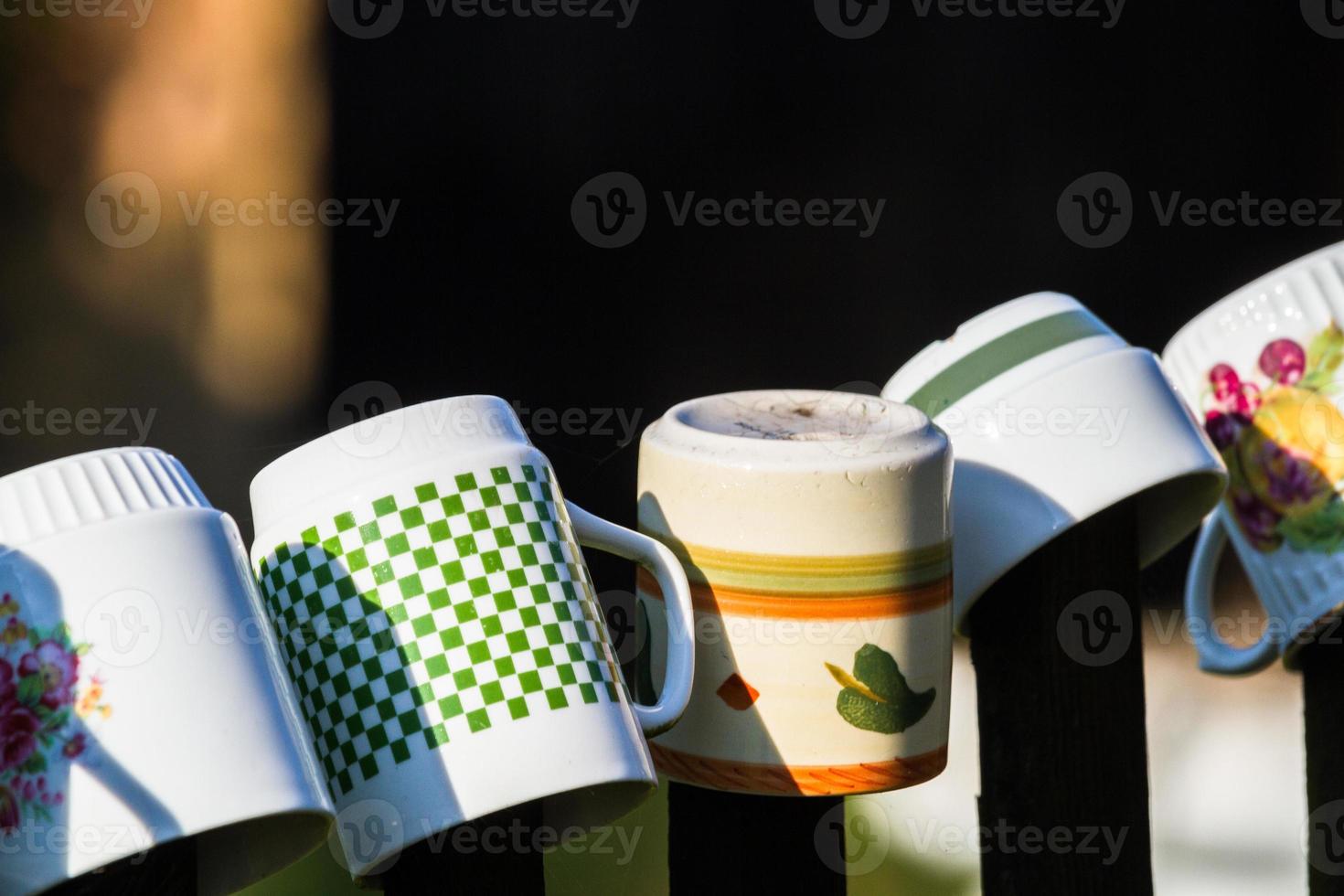 una fila de tazas de café apiladas en la cerca foto