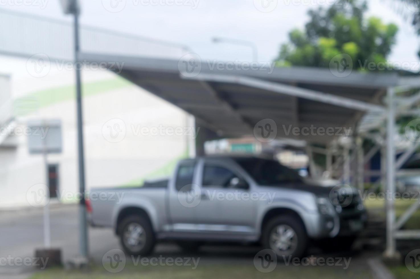 Blurred photo, Defocused picture, Pickup truck and cars parking orderly at department store parking lot, open area parking lot with roof photo