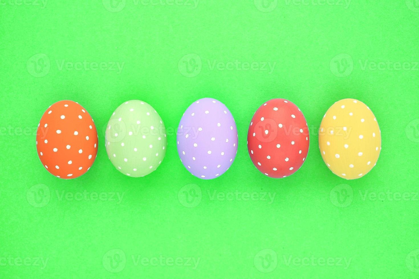 Easter coloured eggs with polka dot on green background. Flatlay postcard creative concept. Isolated decorated card, poster, banner, web, magazine. Minimal idea with copy space, close up spring photo