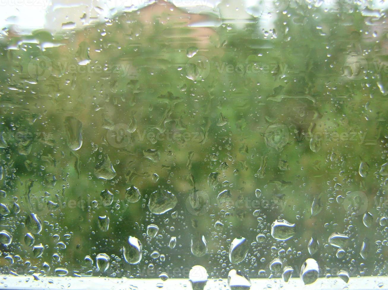 días de lluvia gotas de lluvia en la superficie de la ventana foto