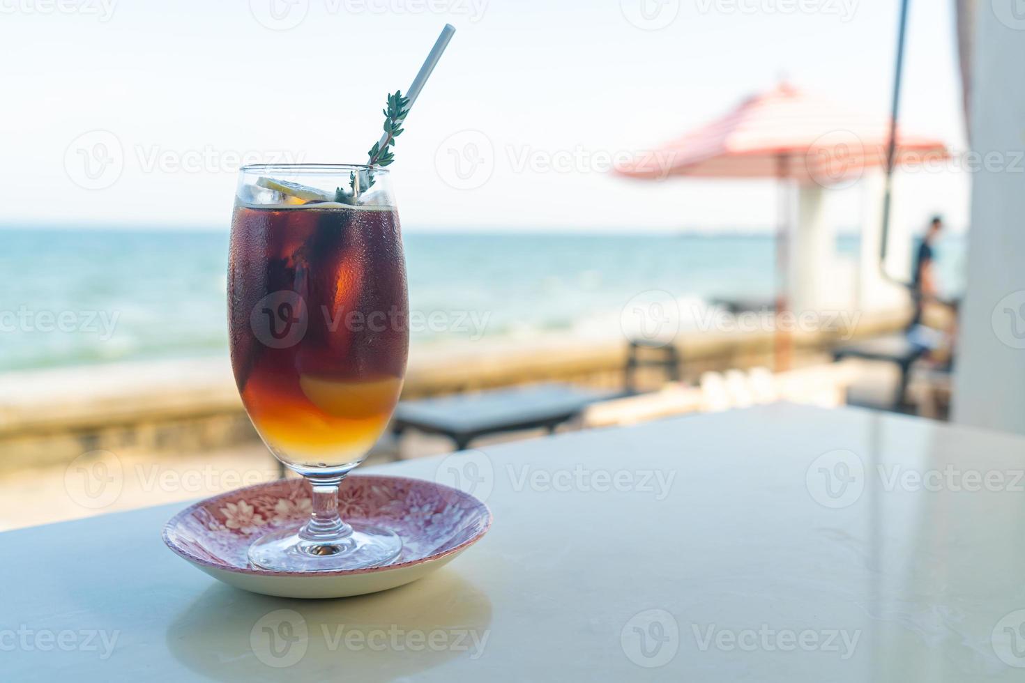 iced americano coffee peach with sea background photo