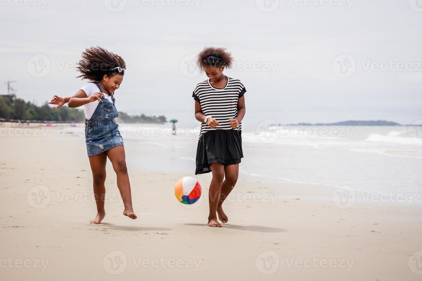 vacaciones divertidas. niños o niños jugando a la pelota y divirtiéndose en una playa tropical foto