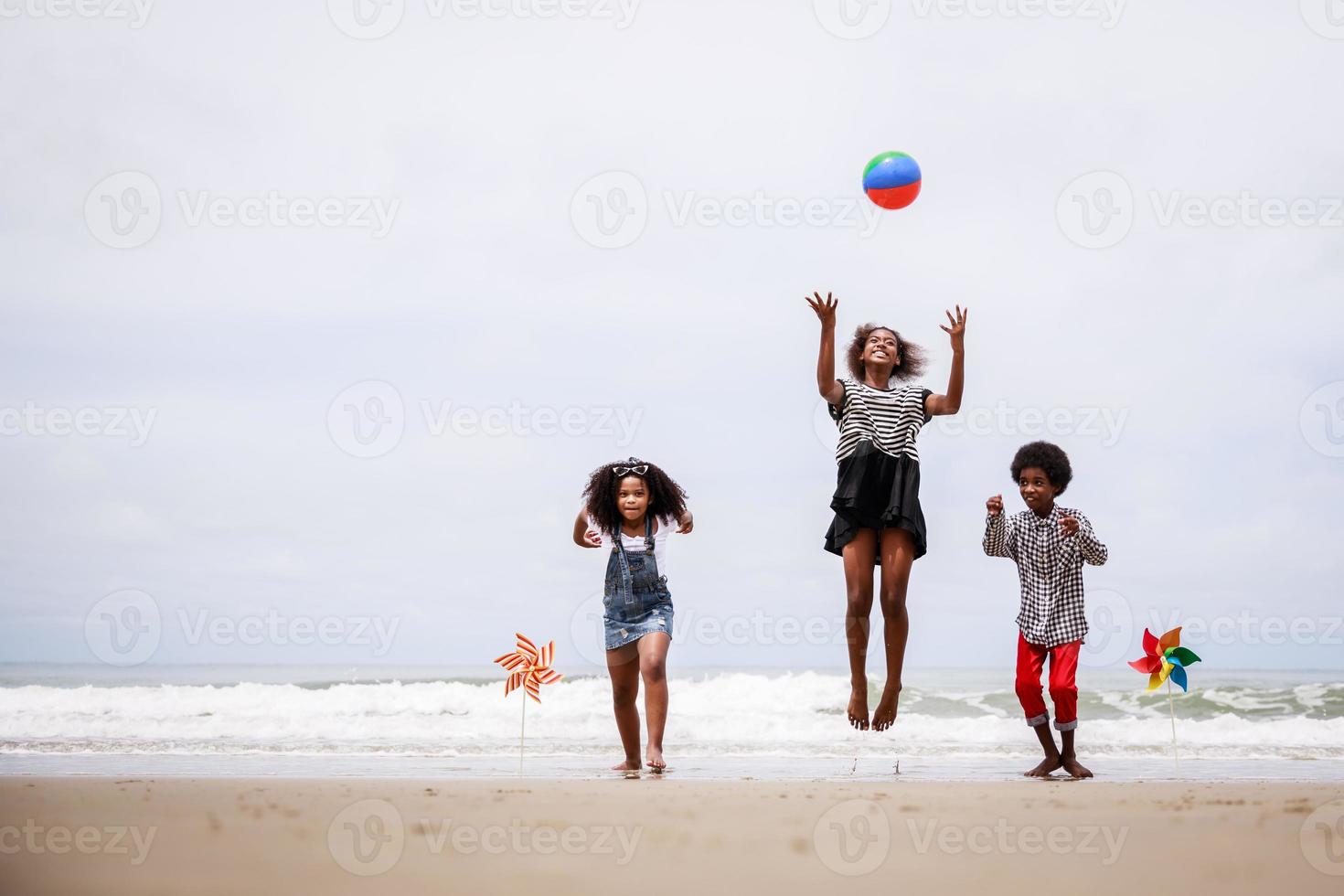 Group of Happy African American children jumping on a tropical beach. Ethnically diverse concept photo