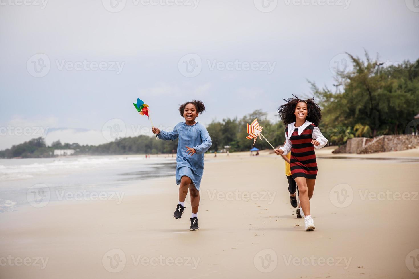 Happy Group of African American children playing on the beach against clear sky photo