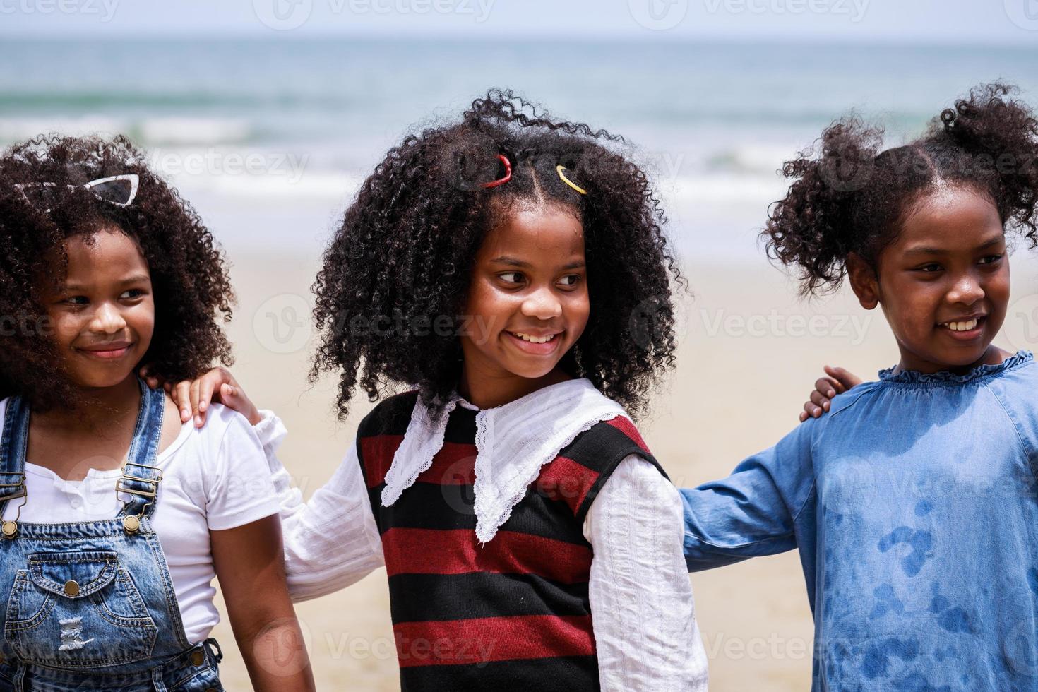 cerca de una feliz chica afroamericana en una playa tropical. Diversidad étnica foto