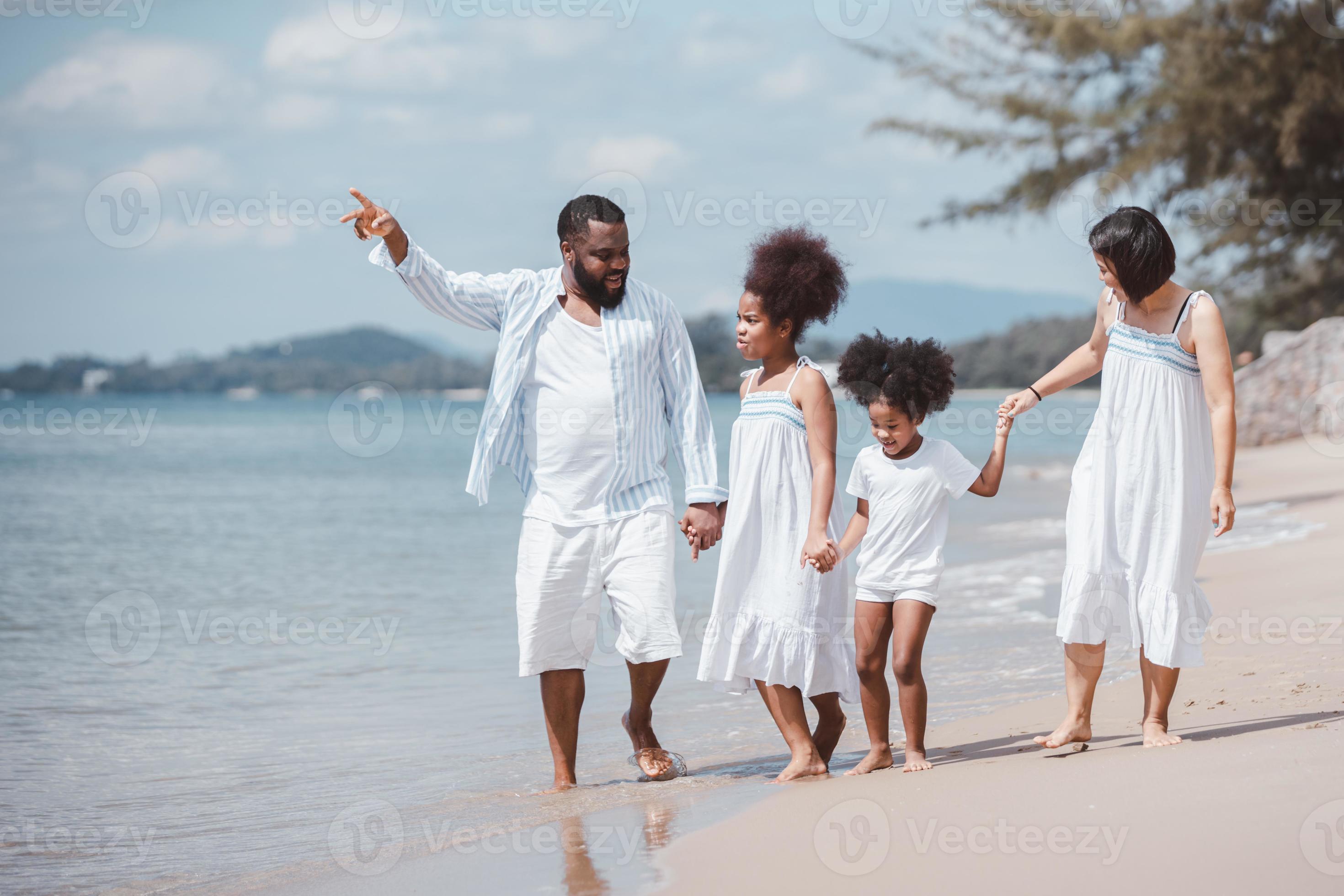 African American family walking together on the beach on holiday