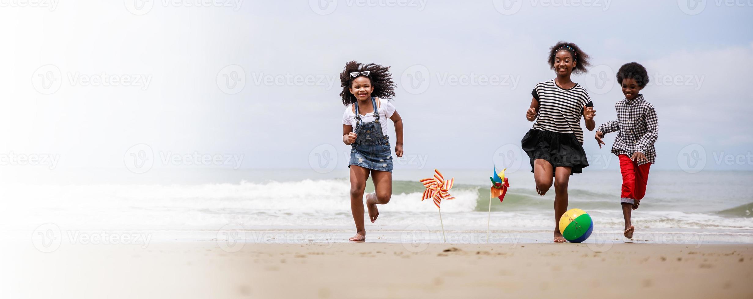 Banner size. Group of Happy African American children running on a tropical beach photo
