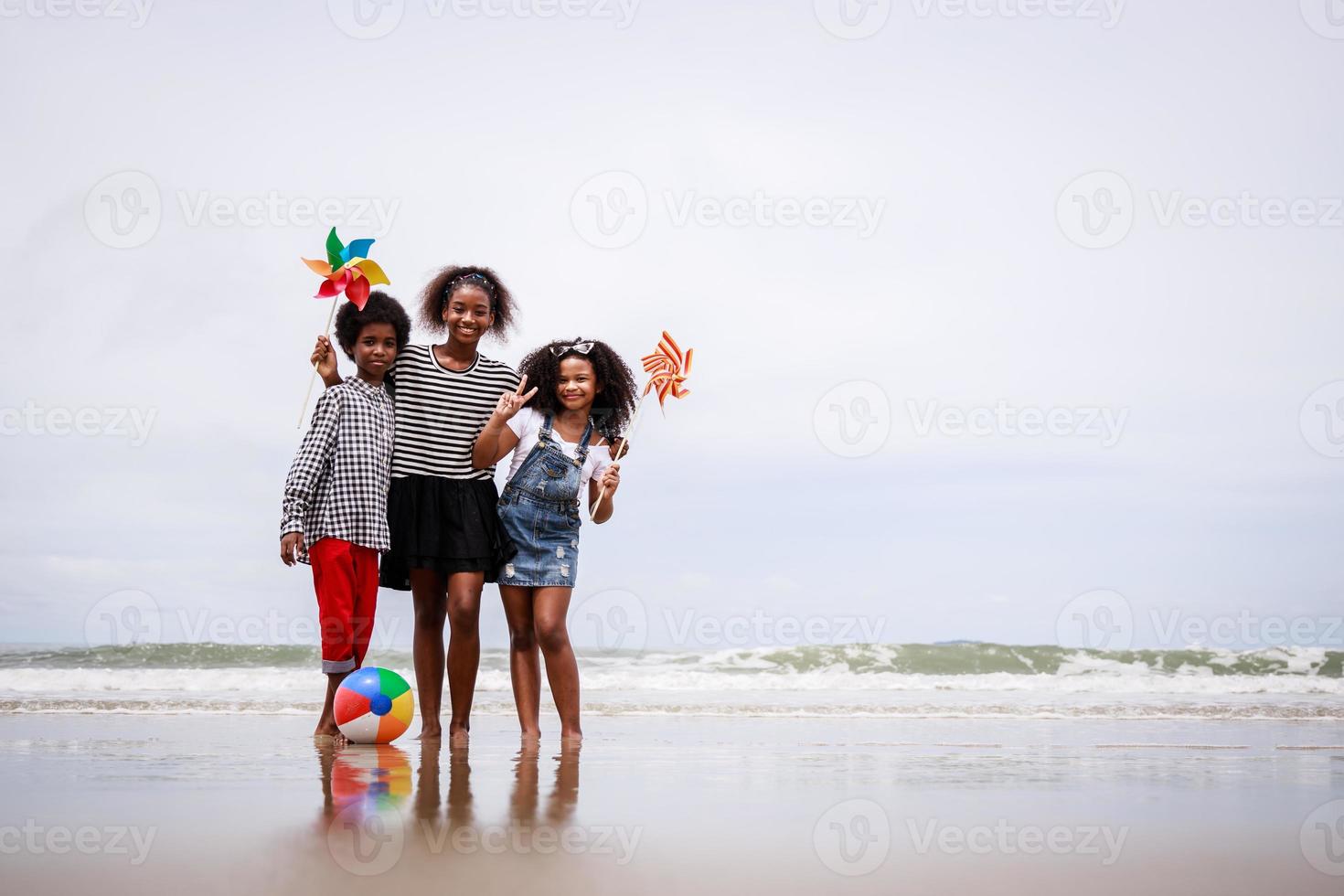 Happy moment of African American kids on a tropical beach. Ethnically diverse concept photo