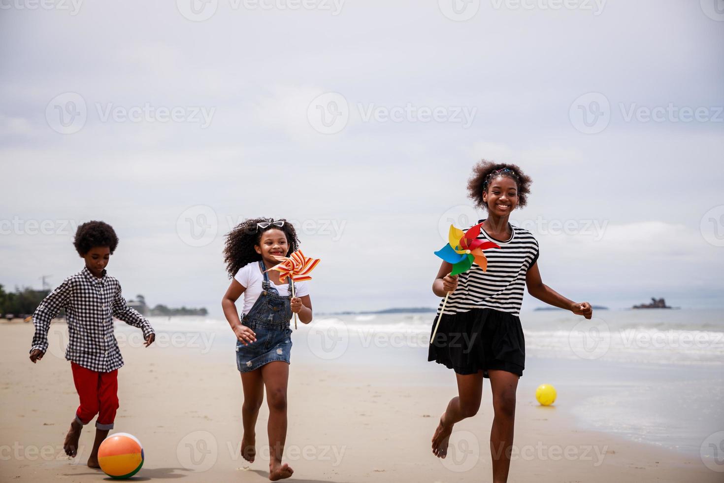 tres niños afroamericanos divirtiéndose en una playa tropical. concepto étnicamente diverso foto