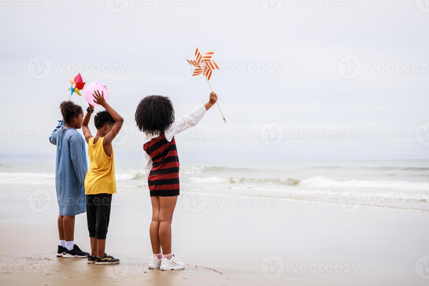 vista lateral de un grupo de niños afroamericanos en la playa. concepto étnicamente diverso foto