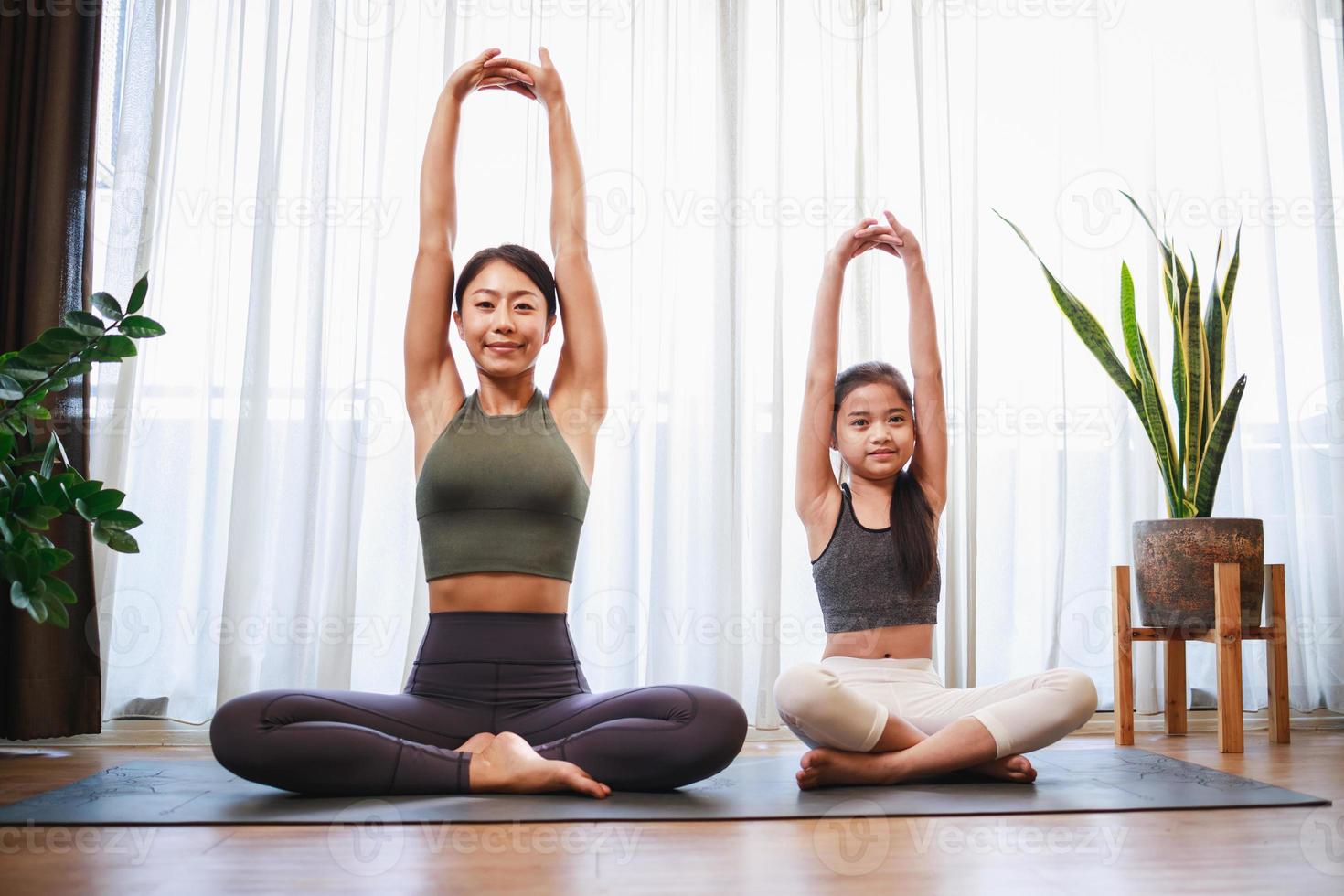 la joven madre y su hija se preparan para posar juntas en el salón de yoga y meditación foto