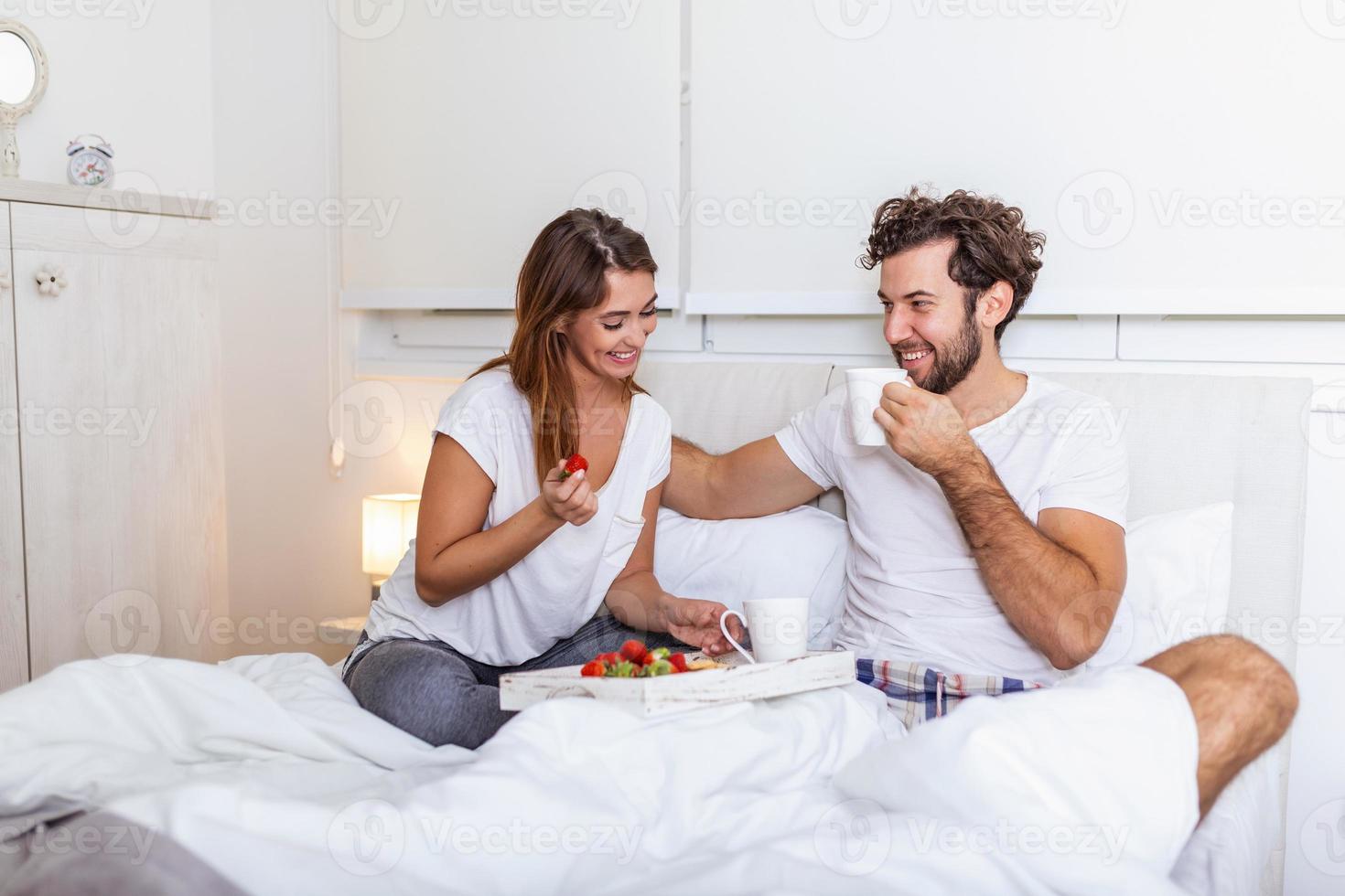 desayuno romántico en la cama hombre preparado para su mujer, ella estaba muy feliz, joven hermosa pareja en la cama desayunando y tomando café en la cama foto