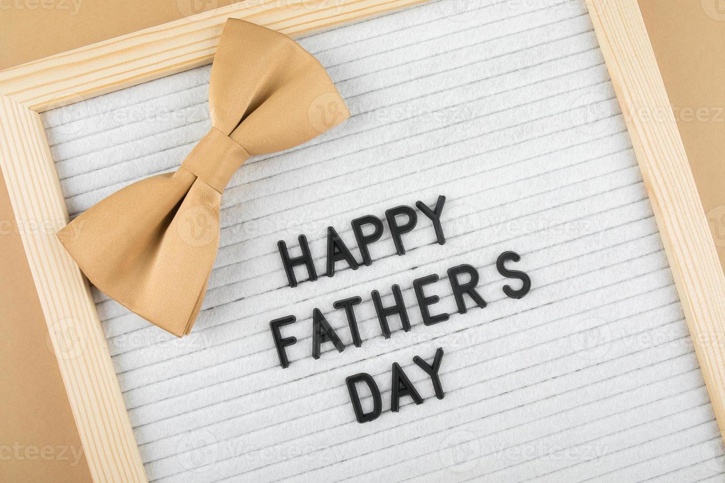 Letter board with congratulations lettering Happy Father's Day and accessory men's butterfly. photo