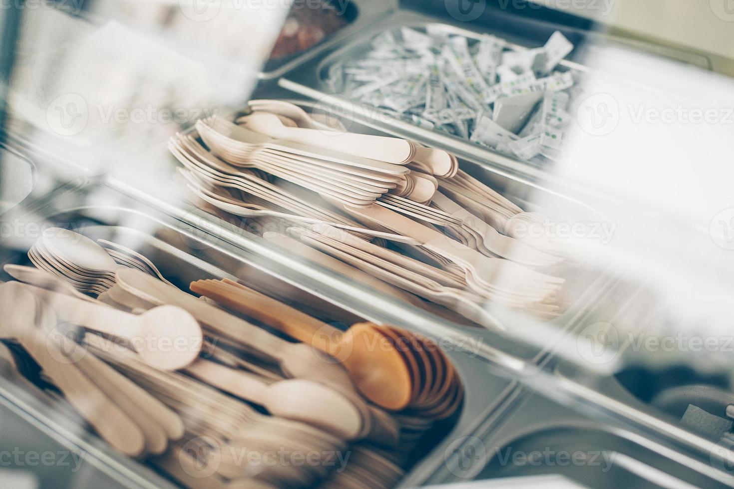 muchas cucharas y tenedores de madera en un recipiente metálico. concepto de cero residuos, artículos ecológicos y orgánicos foto