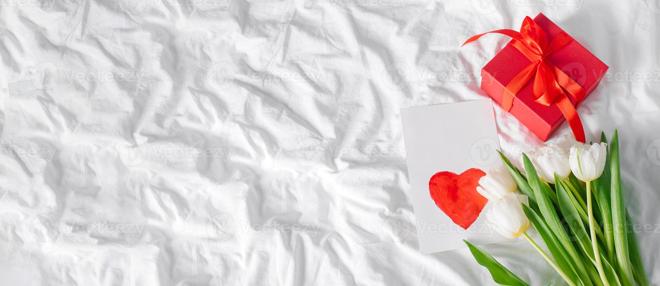 Tulips flowers, red gift box and empty card with heart for text. Mockup. Concept of womens day, mothers day photo