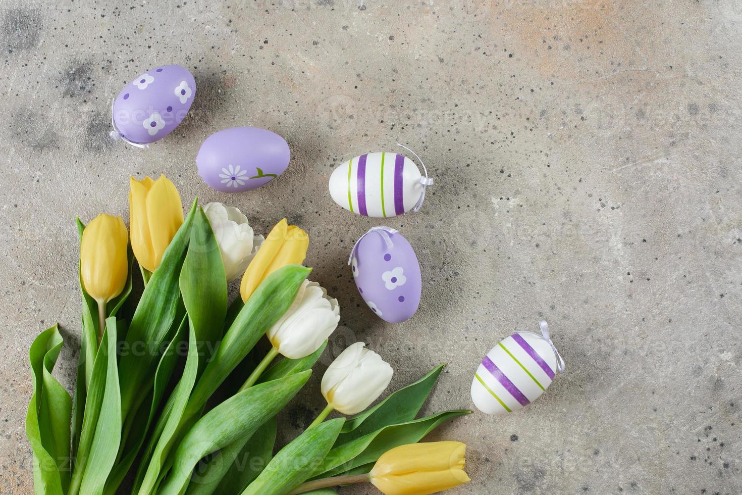 feliz concepto de fondo de vacaciones de pascua. flores de tulipanes y huevos de pascua. endecha plana, espacio de copia foto