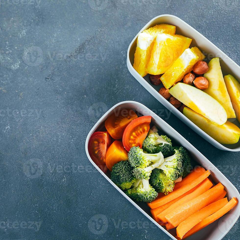 Lunch box with vegetables and fruits. Delicious balanced food concept. Top view, crop square image photo