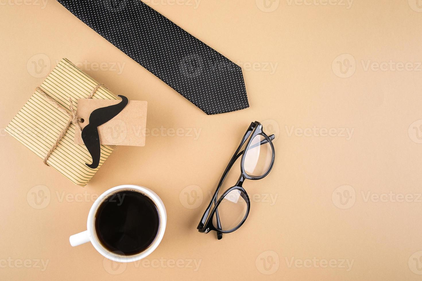 cajas de regalo, bigote de papel, anteojos, corbata, taza de café sobre fondo neutro. concepto de feliz día del padre. vista superior, espacio de copia foto