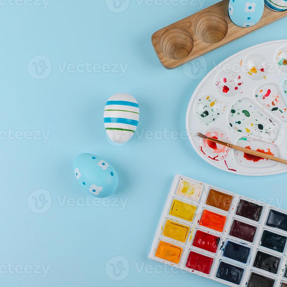 Crop image of flat lay composition with easter eggs and paints photo