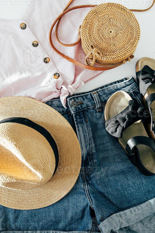 Summer female clothes, accessories. Sandals, denim shirt, top, hat, rattan bag. Beauty blog concept. photo