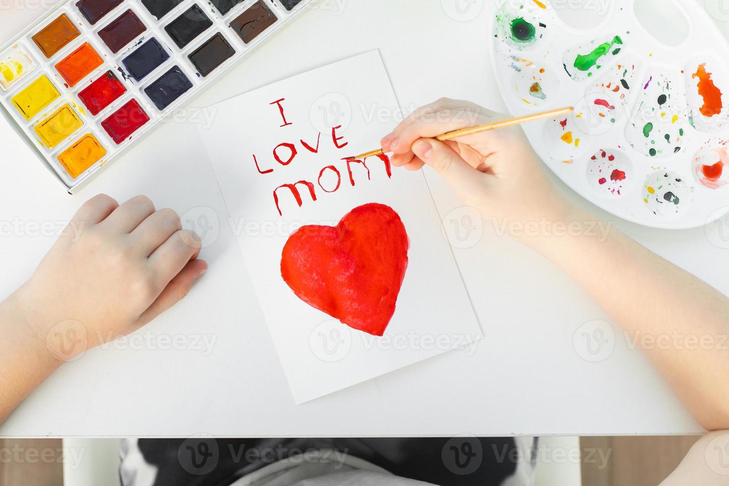Happy Mothers Day. Child girl drawing handmade card for mom for the holiday with watercolors. photo