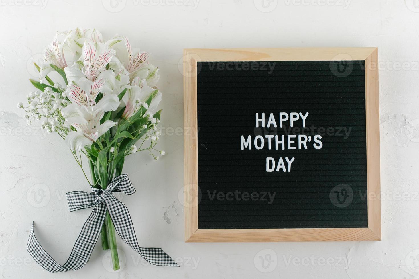 tarjeta de felicitación del día de la madre. alstroemeria, gypsophila, tablero de letras con texto feliz día de la madre foto