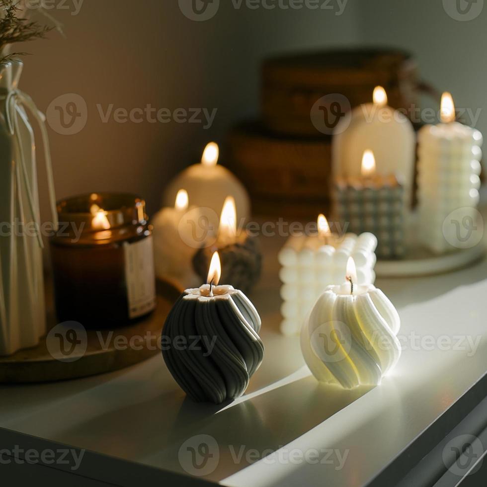 Cozy burning candles on white shelf. Concept of winter or autumn home interior decor photo