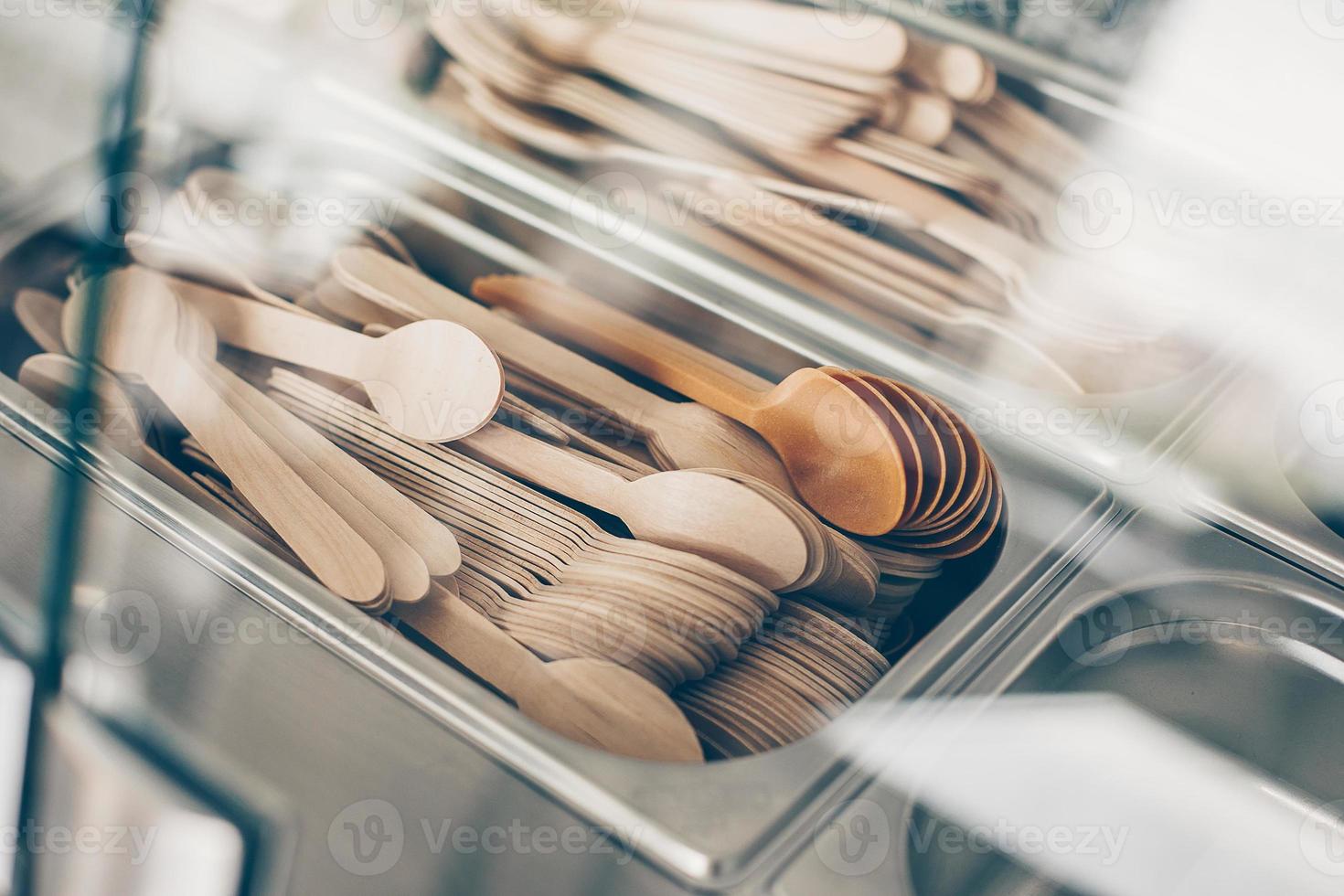 muchas cucharas y tenedores de madera en un recipiente metálico. concepto de cero residuos, artículos ecológicos y orgánicos foto