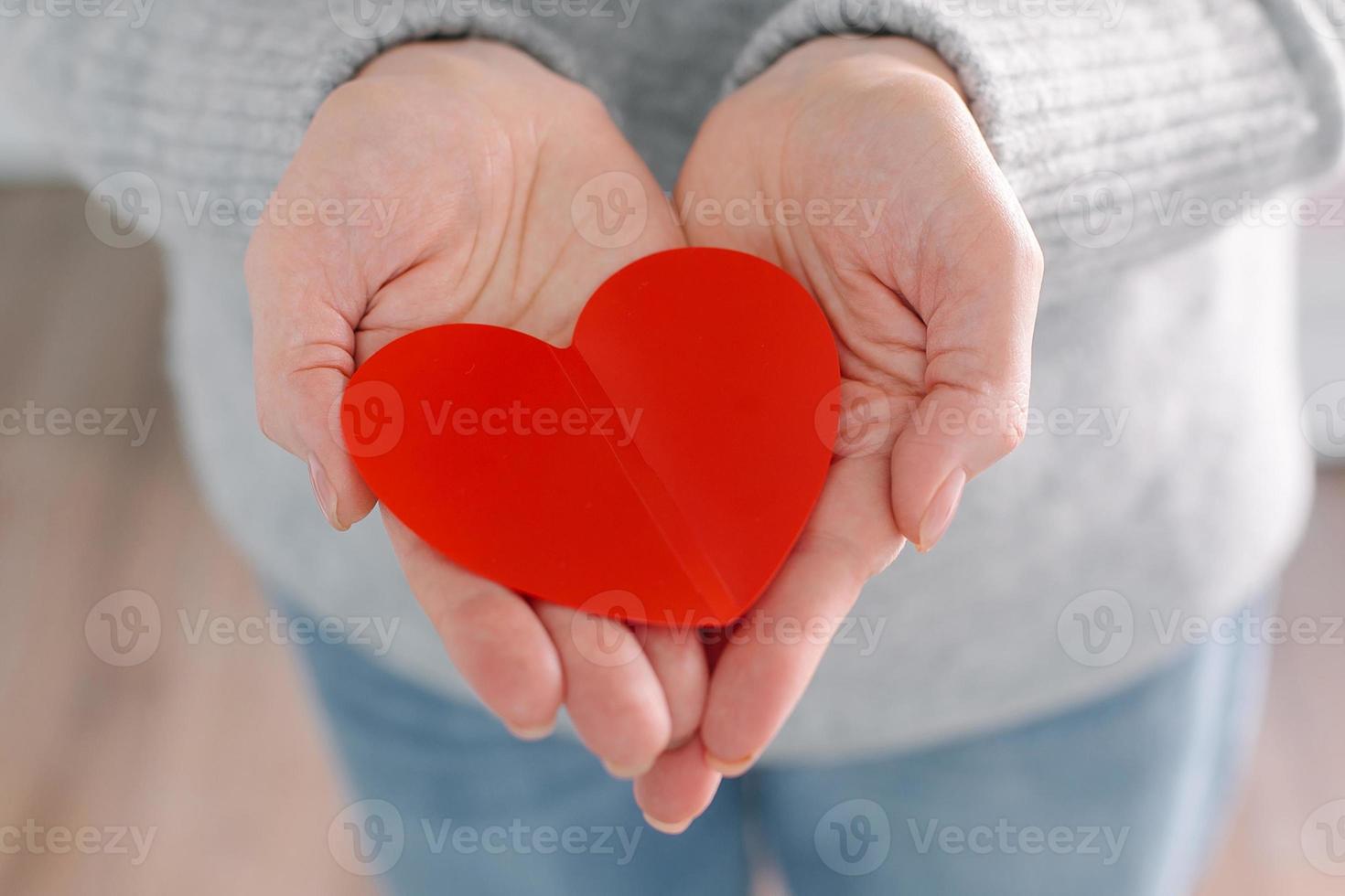 manos femeninas con corazón rojo. concepto de atención médica, donación, bienestar. foto