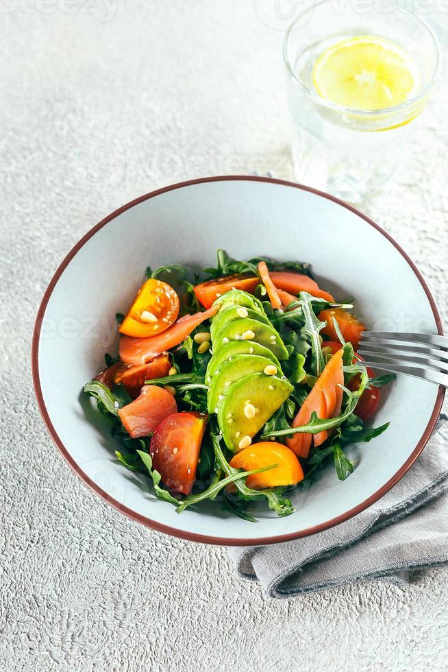 Vertical shot of arugula , salmon, avocado, tomato salad. Healthy eating, living. Top view, vertical photo