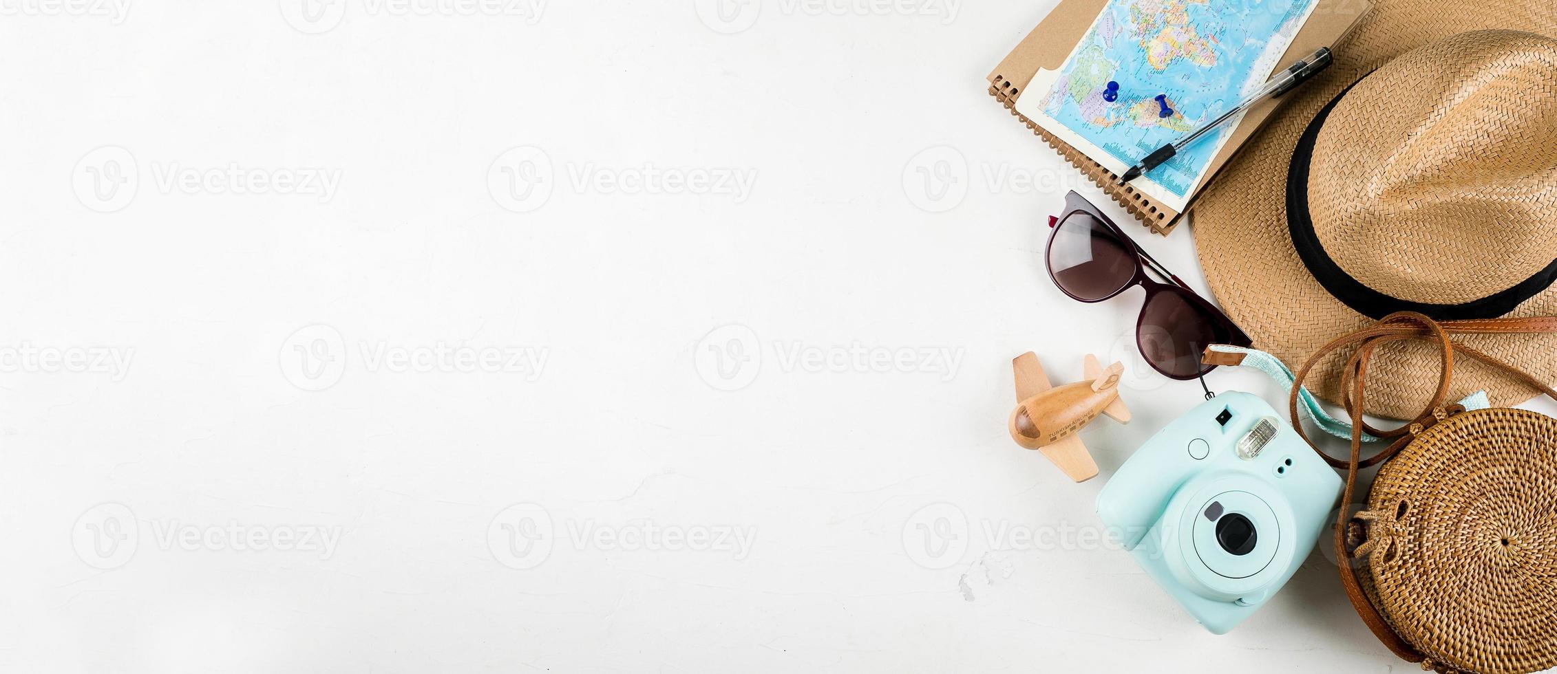 Travel flat lay. Rattan bag, straw hat, sunglasses, camera and airplane. Top view, copy space photo