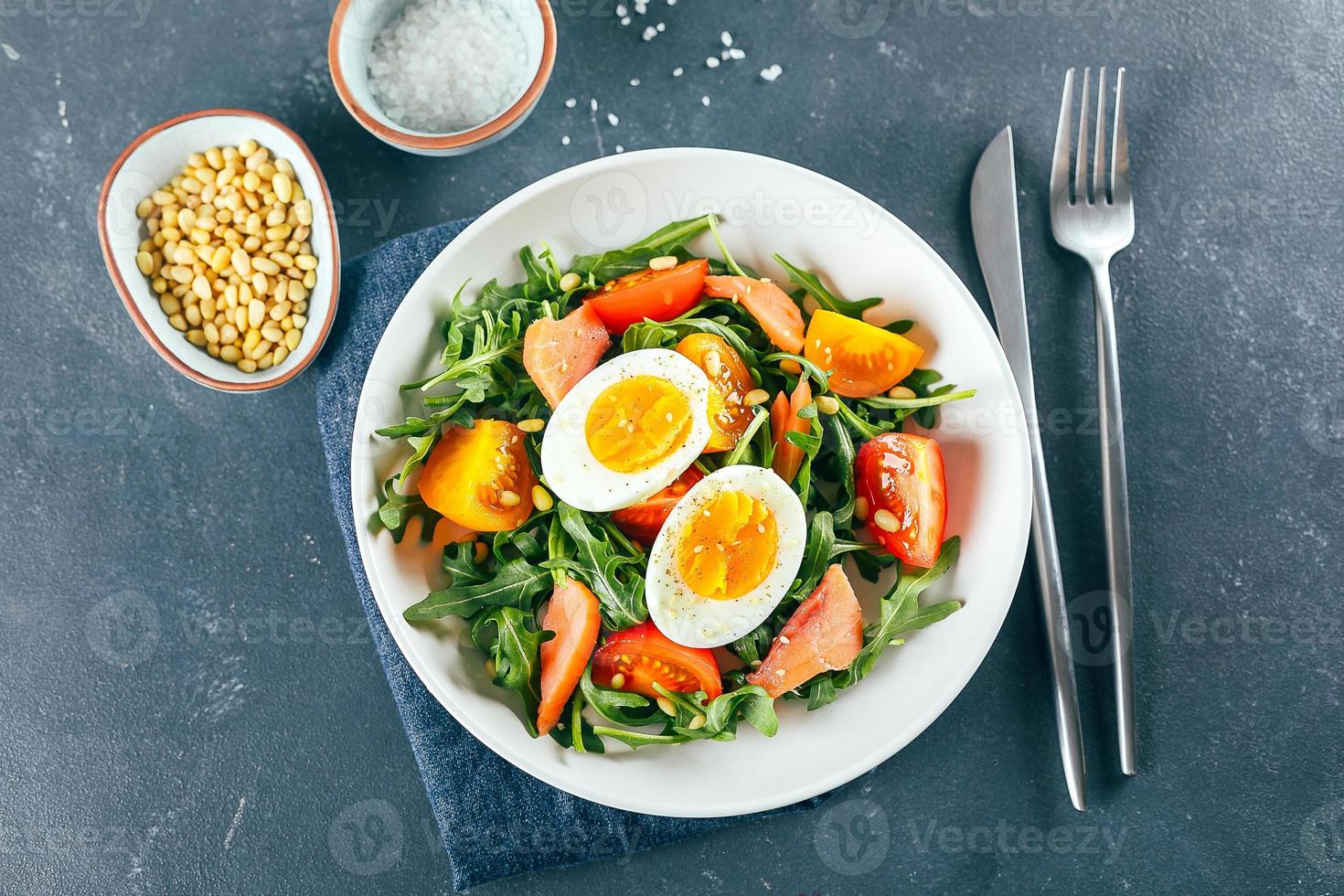 Lunch salad in white plate on blue background. Top view, Healthy food concept photo