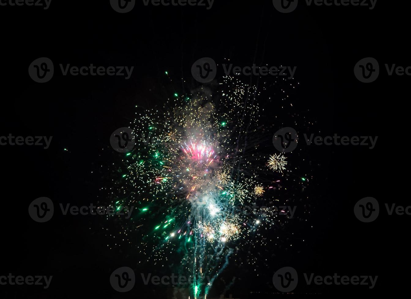 Beautiful colorful firework explosions and sparkles on a night black sky photo