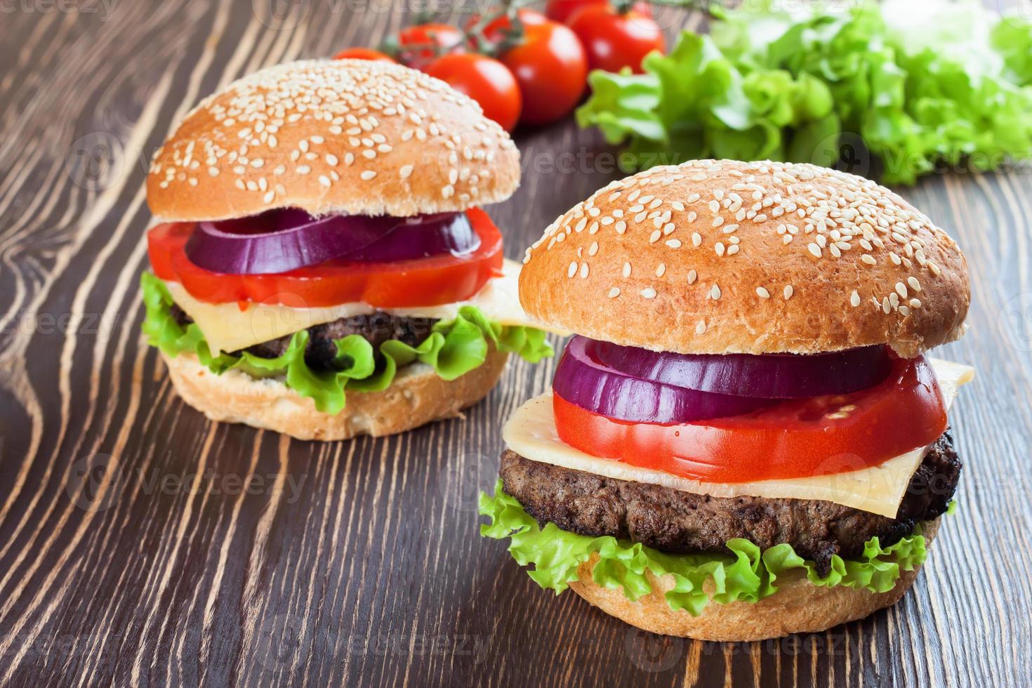 Homemade cheeseburger on brown wooden surface. photo