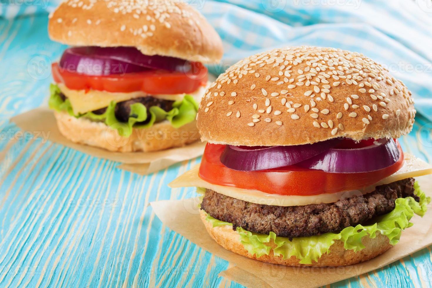 Homemade cheeseburger on blue wooden surface. photo